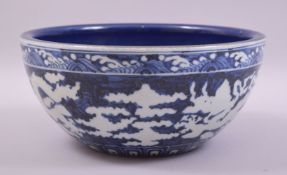 A LARGE CHINESE SACRIFICIAL BLUE GLAZE DRAGON BOWL, the exterior with white dragons and clouds