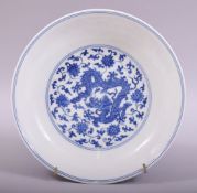A GOOD CHINESE BLUE AND WHITE PORCELAIN DISH, the centre painted with a dragon amongst lotus and