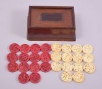 A SET OF FOURTEEN CHINESE CANTON PIERCED IVORY RED AND WHITE STAINED COUNTERS, 3cm diameter,