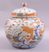 A LARGE CHINESE WUCAI PORCELAIN JAR AND COVER, the body painted in the wucai palette with fish and