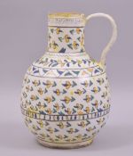 A TURKISH KUTAHYA GLAZED POTTERY WATER JUG, painted with foliate motifs, 20cm high.