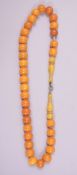 A FINE SET OF CHINESE OR ISLAMIC AMBER BEADS, comprising 33 spherical beads; each approx. 12mm,
