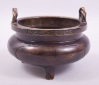 A CHINESE BRONZE TWIN HANDLE TRIPOD CENSER, with rope form handles, the rim with six character