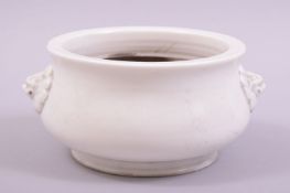 A CHINESE DEHUA PORCELAIN CENSER, with moulded lion masks either side, 15.5cm diameter.