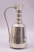 AN IRAQI WHITE METAL EWER, with engraved landscape scene, 23cm high.
