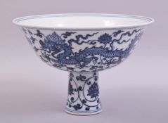 A CHINESE BLUE AND WHITE PORCELAIN STEM CUP, the exterior decorated with dragons, flower heads and