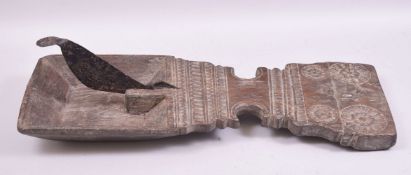 A LARGE 18TH/19TH CENTURY CARVED WOODEN COCONUT CUTTER TRAY, overall measuring 63cm long.