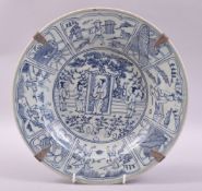 A CHINESE BLUE AND WHITE PORCELAIN DISH, painted with panels figures and objects, 29.5cm diameter.