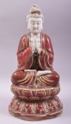 A CHINESE DEHUA COPPER RED GLAZE FIGURE OF GUANYIN, seated upon a lotus base, with marks to the