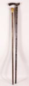TWO WOODEN INDIAN WALKING STICKS - the larger with white metal and gilt inlaid decor, 93cm high, the