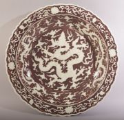 A LARGE CHINESE IRON RED UNDERGLAZED DRAGON DISH, decorated with a large dragon amongst stylised