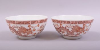 A SMALL PAIR OF CHINESE RED AND WHITE PORCELAIN BOWLS, each bowl decorated with a dragon and phoenix