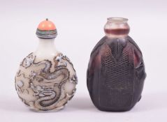 TWO CHINESE SNUFF BOTTLES, one opaque glass with coral stopper, the other amethyst glass (lacking