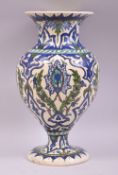 A TURKISH OTTOMAN KUTAHYA GLAZED POTTERY VASE, painted with sprays of stylised flora, 31.5cm high.