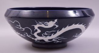 A VERY LARGE CHINESE SACRIFICIAL BLUE GLAZED BOWL, the exterior decorated with white dragons, 38cm