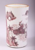 A CHINESE UNDER GLAZED RED PORCELAIN BRUSH POT, painted with figures and a dragon in a lake scene,