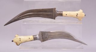 TWO 18TH/19TH CENTURY MUGHAL INDIAN DAGGERS, both with two piece bone handles, one with leather