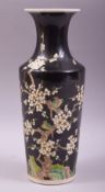 A CHINESE FAMILLE NOIR PORCELAIN VASE, painted with birds upon prunus blossom, six character mark to