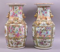 A PAIR OF CHINESE CANTON PORCELAIN VASES, decorated with panels of figures and native flora, the