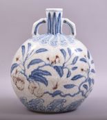 A CHINESE MING STYLE BLUE AND WHITE AND UNDER GLAZED RED TWIN HANDLE MOONFLASK VASE, decorated