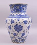 A LARGE TURKISH IZNIK BLUE AND WHITE POTTERY VASE, painted with stylised flower heads, 31cm high.