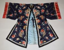 A VERY GOOD QUALITY CHINESE EMBROIDERED BLUE SILK KIMONO, embroidered with bats, fruit and flowers.