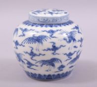A SMALL CHINESE BLUE AND WHITE PORCELAIN JAR AND COVER, painted with cranes amongst stylised clouds,