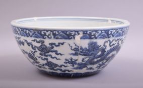 A LARGE CHINESE BLUE AND WHITE DRAGON BOWL, the exterior painted with dragons amongst stylised