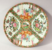 A CHINESE CANTON PORCELAIN PLATE, painted with panels of figures, birds and butterflies, 30.5cm.