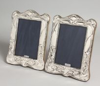 A PAIR OF ART NOUVEAU DESIGN SILVER PHOTOGRAPH FRAMES. 7.5ins x 5.5ins.