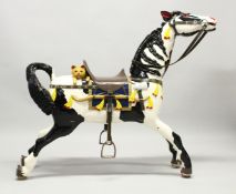 A PERIOD CARVED WOOD RE-PAINTED FAIRGROUND HORSE, a carved cat on its back. 3ft 9ins long, 3ft