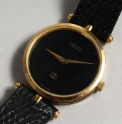 A GUCCI BLACK FACED WRIST WATCH with leather strap.