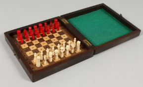 A SMALL COLUMD IVORY TRAVELLING CHESS SE with folding case board. 5.75ins.