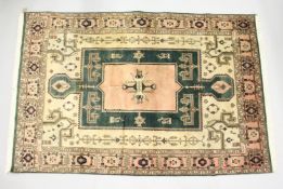 A PERSIAN CARPET, pink and green ground, with stylised decoration. 8ft x6ft 6ins.