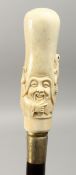A CARVED BONE HANDLED WALKING STICK. Elongated Chinese man's head. 34ins long.