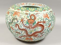 A GOOD CHINESE PORCELAIN CIRCULAR YELLOW, RED AND GREEN DRAGON POT, 14ins diameter.