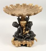 A GOOD BRONZE AND ONYX COMPORT as three cupids holding a shell, 12ins high.