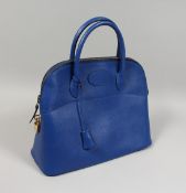 A BLUE LEATHER BAG with chrome lock. 13.5ins x 11ins