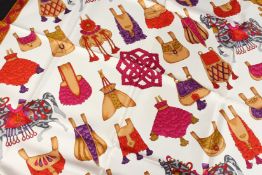 A SALVATORE FERRAGAMO SILK SCARF, cream ground, red and black border with toy horse. 72ins x 68ins.
