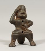 A SOUTH AMERICAN POTTERY WHISTLE as a seated figure,possibly from Peru. 4ins.