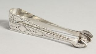 TWO GEORGE III BRIGHT CUT SUGAR TONGS. London 1792, maker A D & 1790 , maker W S.