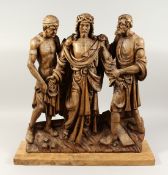 A SUPERB 18TH CENTURY GERMAN CARVED LIMEWOOD GROUP, CHRIST with two men, the base with a cross and