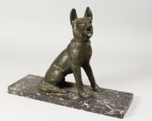 AN ART DECO CAST SPELTER MODEL OF A SEATED ALSATIAN DOG, on a rectangular marble base. 15ins long.