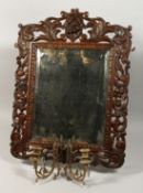 A GOOD EARLY CARVED OAK MIRROR - GIRENDOLE with fittings and bevelled edge mirror. 28ins x 22ins.