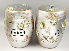 A PAIR OF BLUE AND WHITE BARREL SEATS decorated with birds, 17ins high.