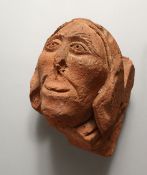 A 17TH CENTURY CARVED TERRACOTTA HEAD. 8.5ins high.