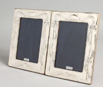 A PAIR OF ART NOUVEAU DESIGN SILVER PHOTOGRAPH FRAMES. 7.5ins x 5.5ins