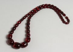 A RED AMBER FIFTY BEAD NECKLACE.