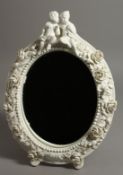 A DERBY WHITE GLAZED EASEL TYPE MIRROR FRAME, floral encrusted, with two children seated on top.