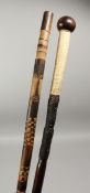 A HEAVY NATIVE WALKING CANE with stringing and carved shaft, 36ins long and a carved bamboo